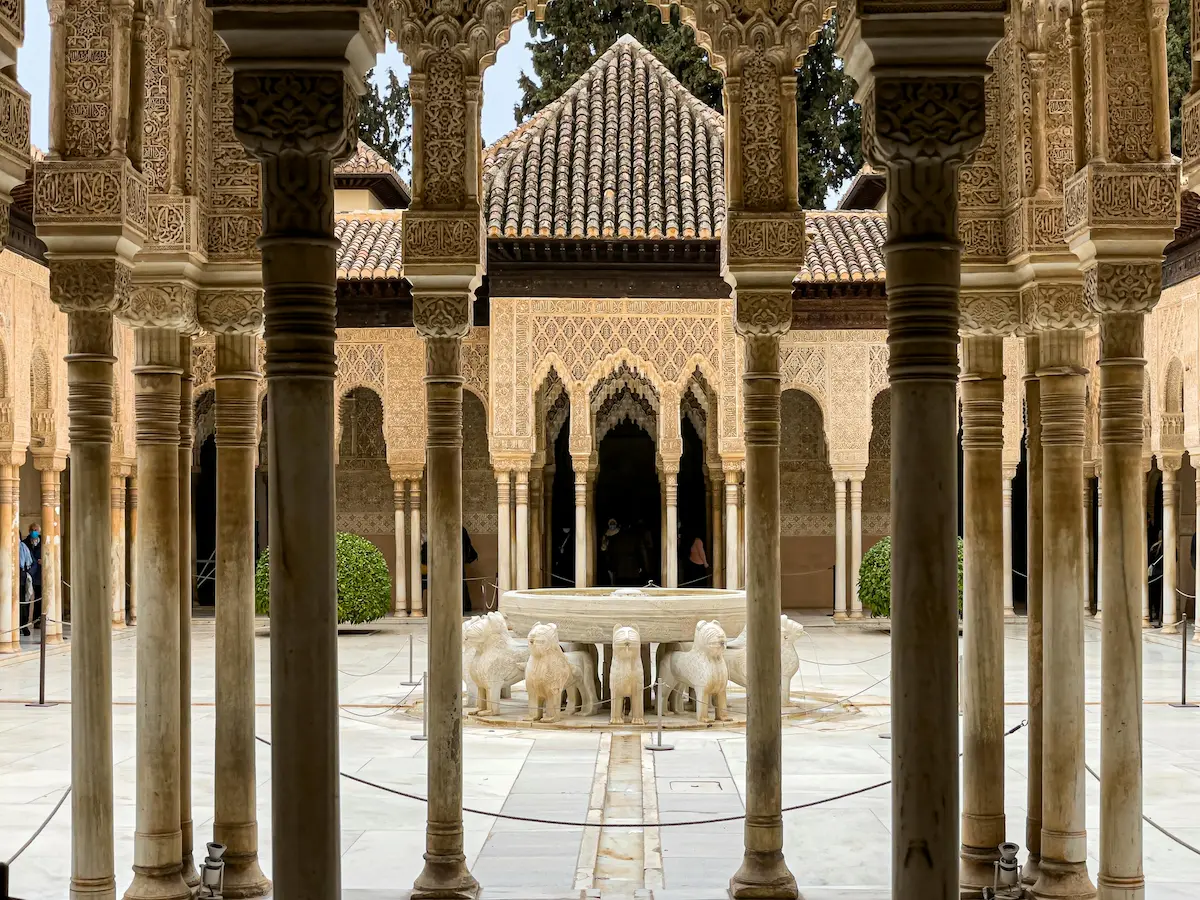 The Courtyard of the Lions at Alhambra Palace, showcasing intricate arches, columns, and the famous lion fountain.