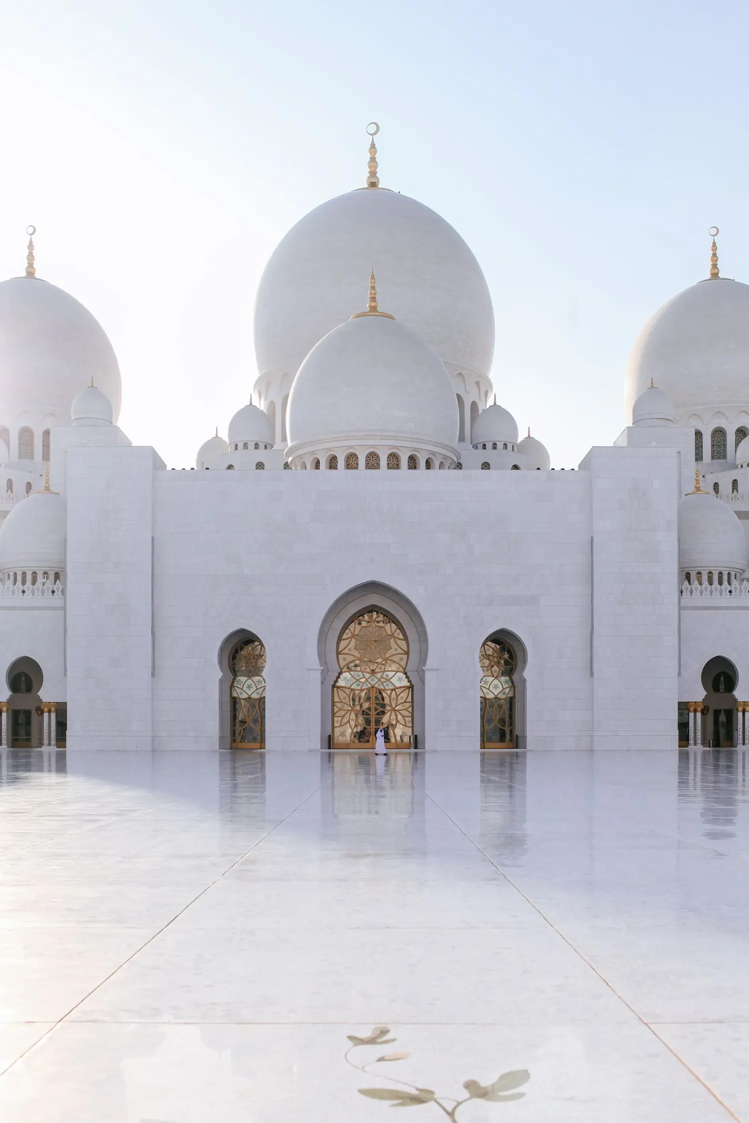 Sheikh Zayed Grand Mosque in Abu Dhabi featuring modern Islamic architecture with grand arches, domes, minarets, and decorative muqarnas patterns.