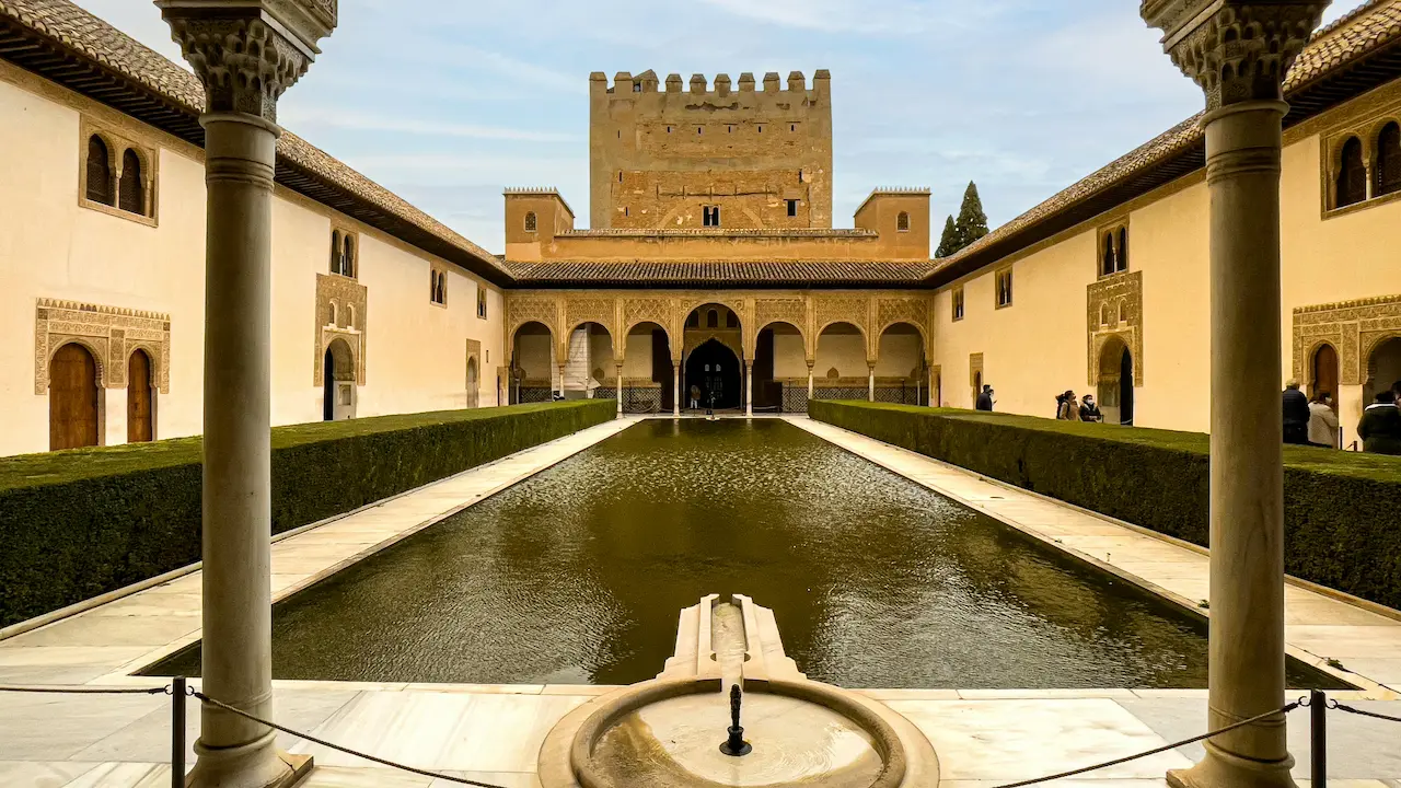 the pool of the court of the myrtles in the alhambra palace complex, granada, spain, reflecting intricate islamic architecture