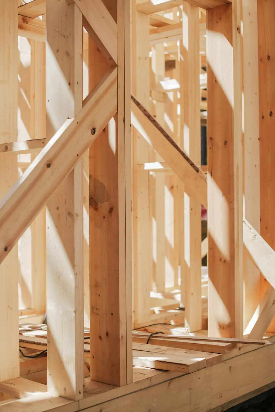 Close-up view of diagonal truss bracing joint in the roof structure of a real house, showing the detailed connection for stability.