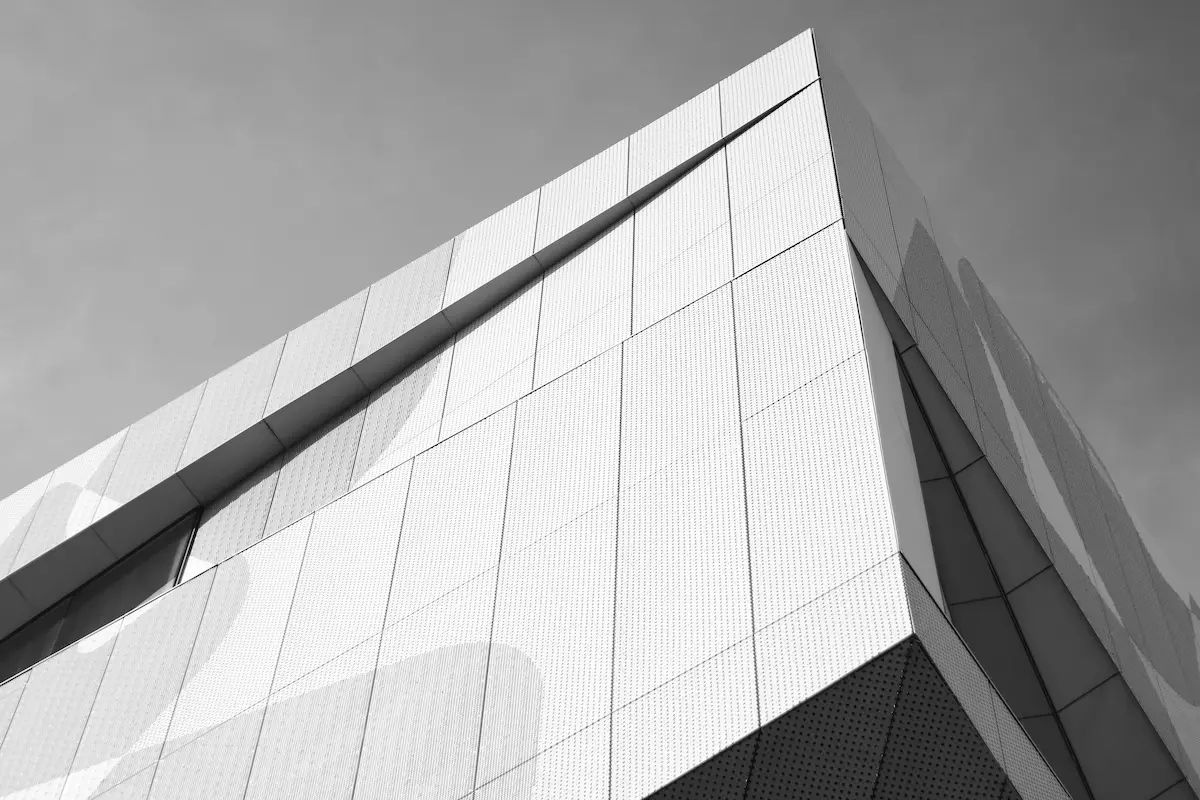grayscale photo of high-rise building in Zaragoza, Spain, featuring clean lines and a sophisticated minimalist design