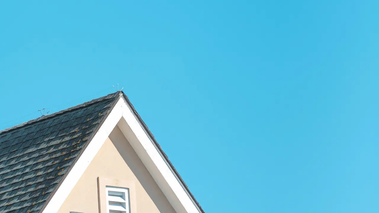 A house featuring a pitched hip roof, offering a stylish and stable design.