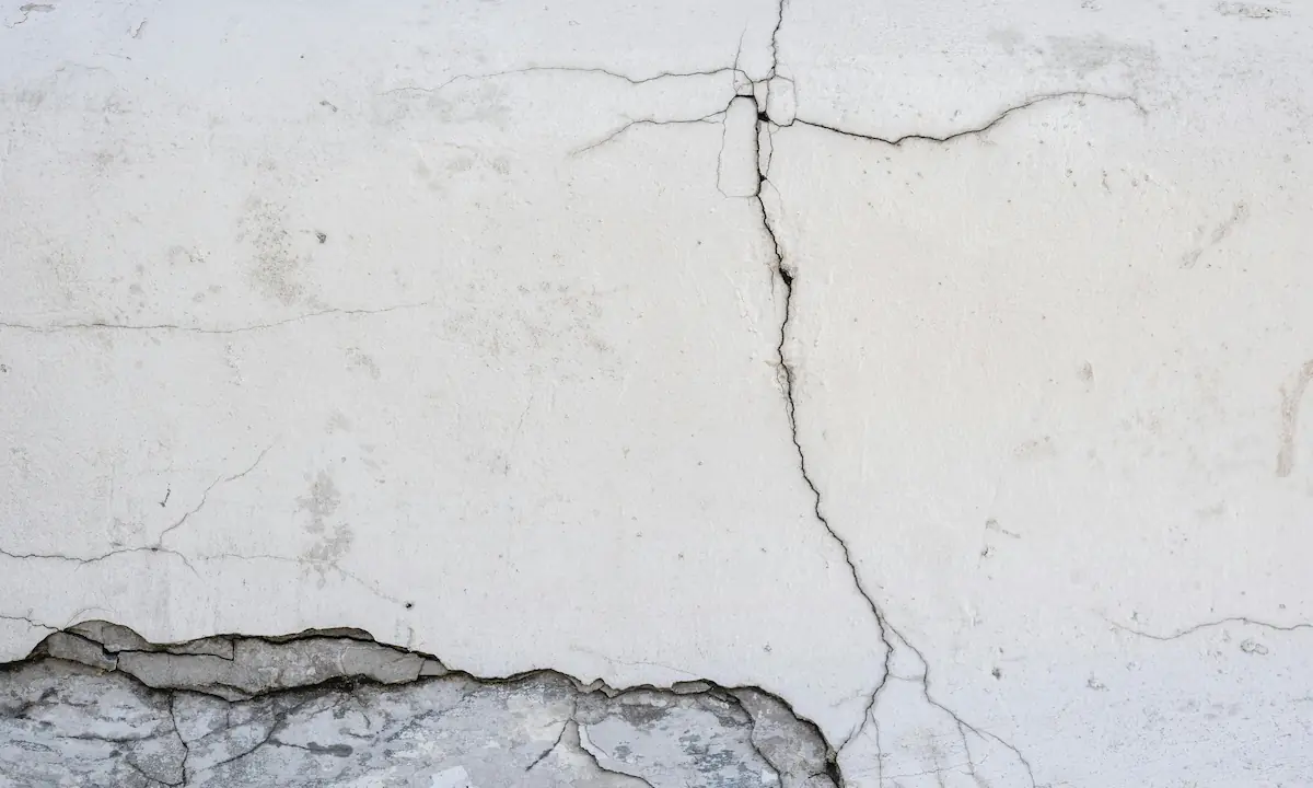 house with visible settling cracks on the foundation and walls