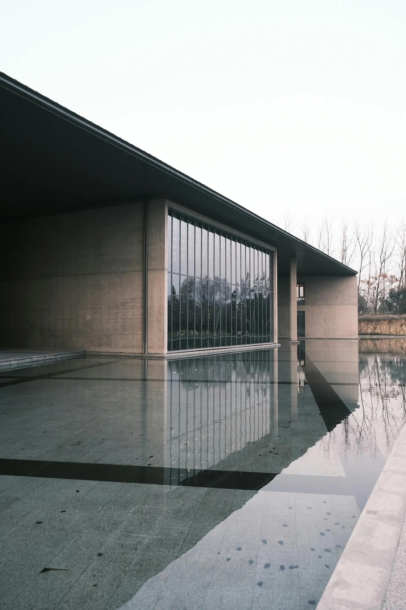 simple concrete building with modern minimalist design and a swimming pool in front