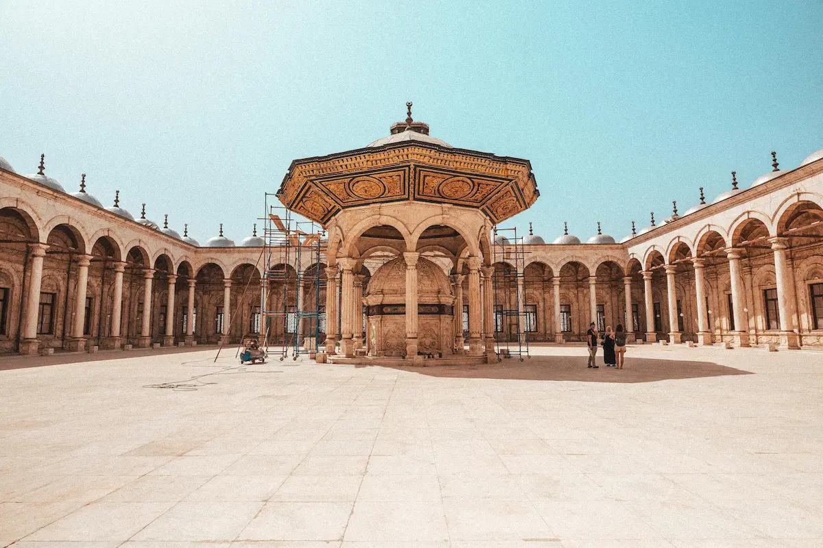 View from the center of the courtyard of the Mohammad Ali Mosque in Cairo, showcasing the intricate arches, wudu area, and architectural details.