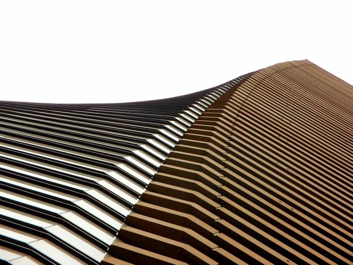 Modern facade of the Pias Building with a sleek, abstract design, featuring metallic textures and contemporary architectural elements.