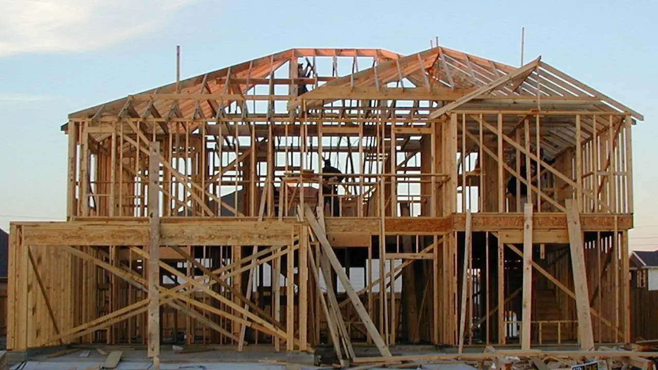 Framing of a house in its final stages, showing the completed structural framework before finishing work begins.