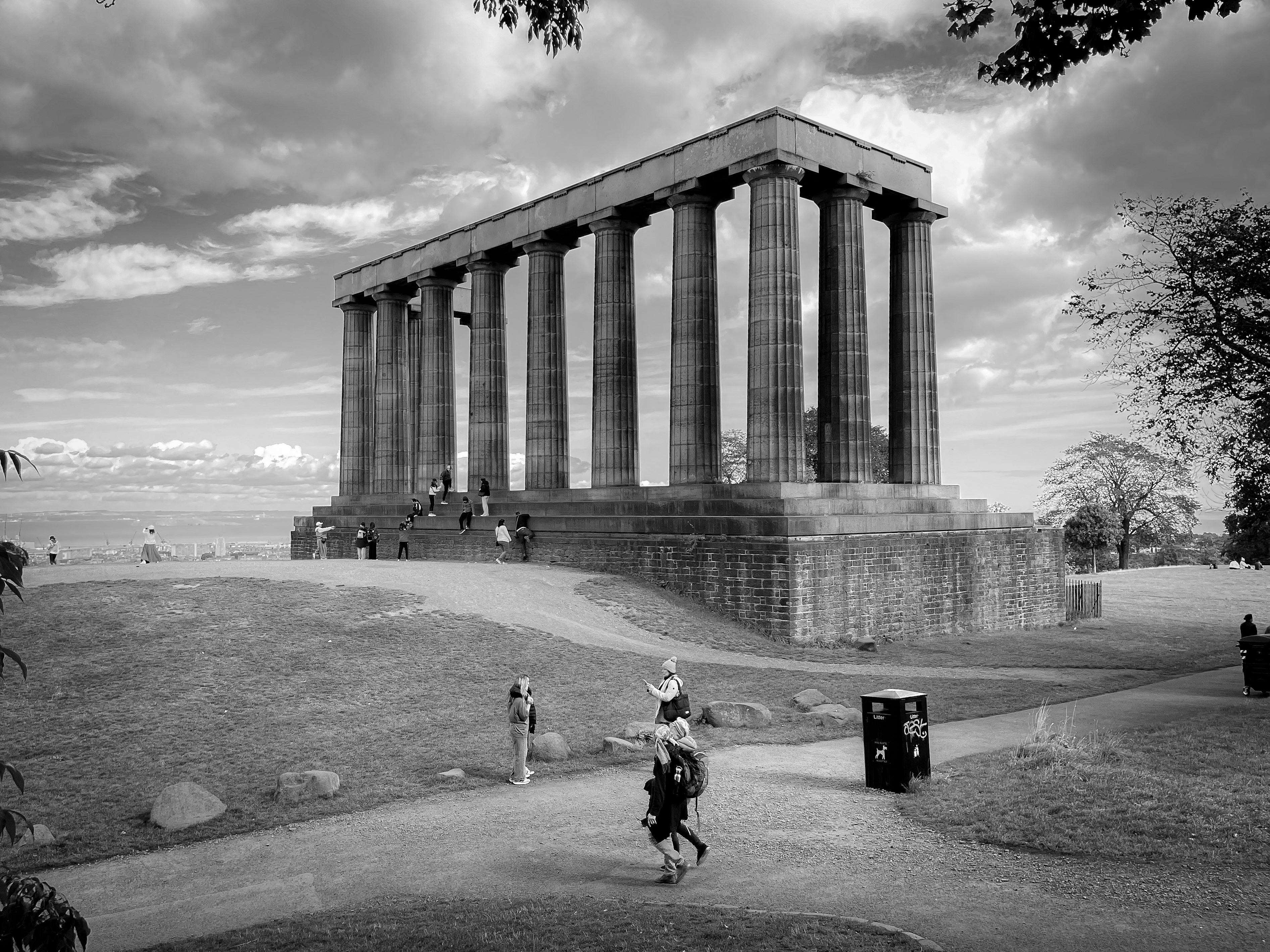 Black and white photo of a Parthenon-style monument in a park setting in Edinburgh.