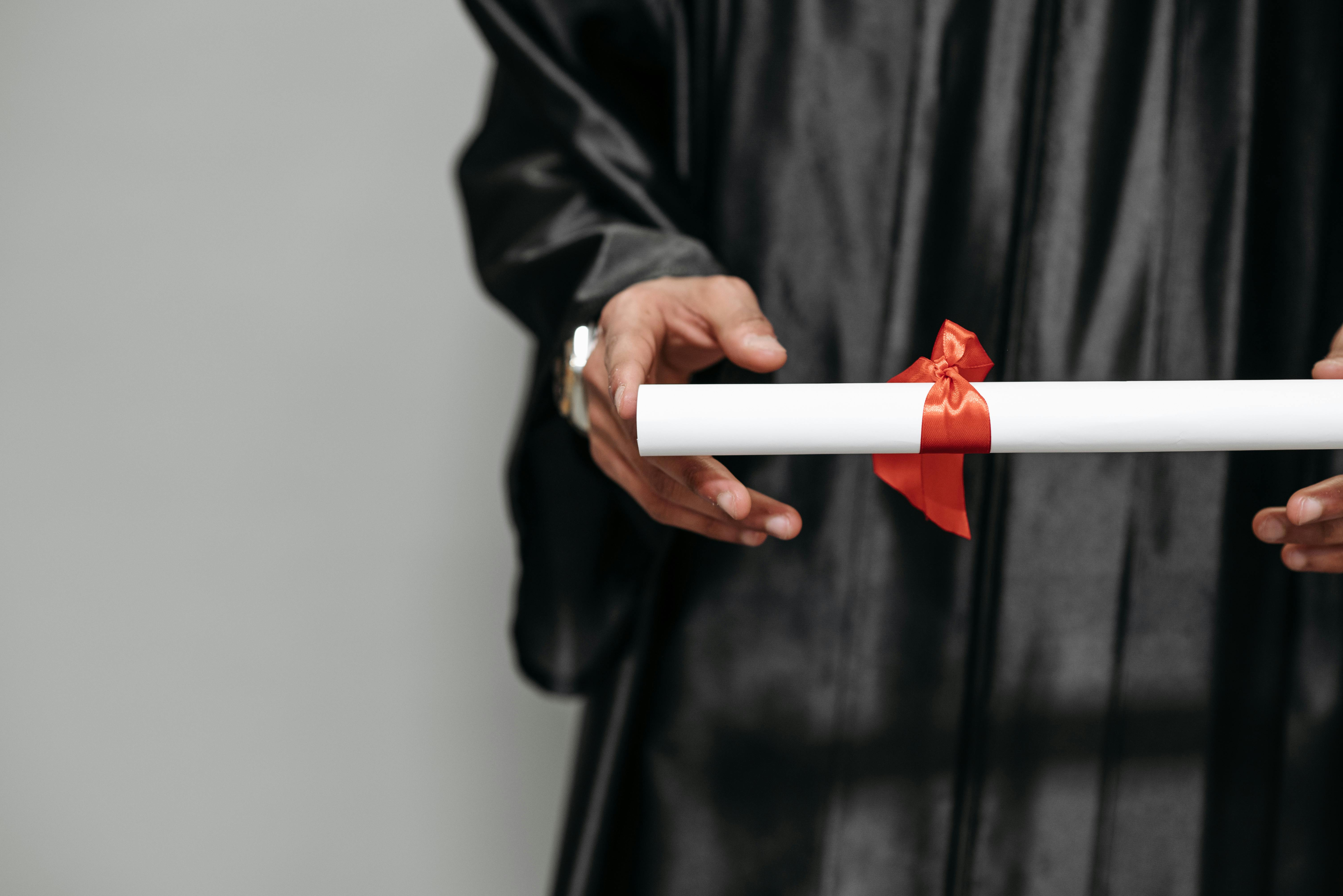 A graduate holding an architecture degree scroll, standing with pride after the ceremony.