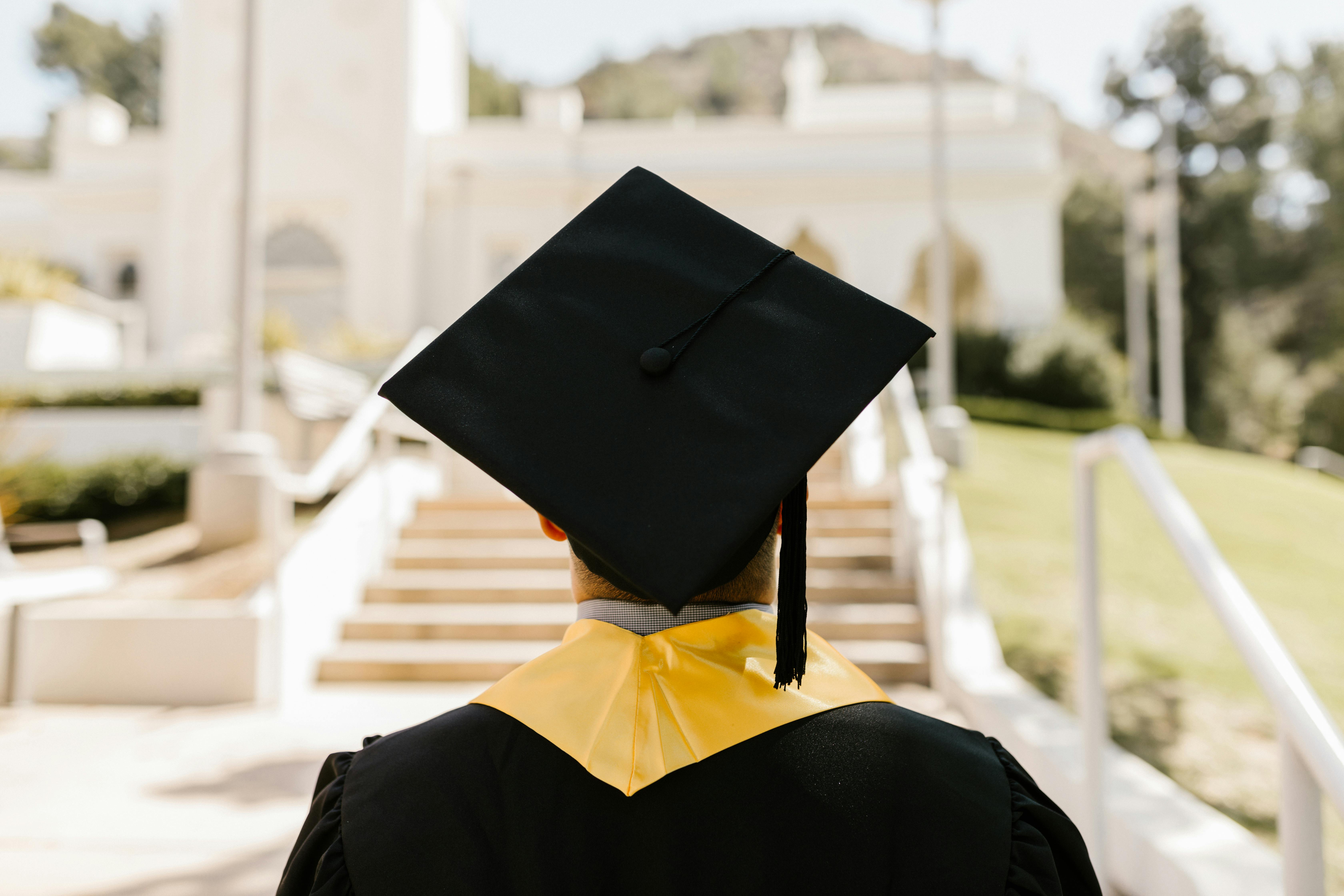 Graduate in gown and mortarboard symbolizing completion of architecture and psychology degree.