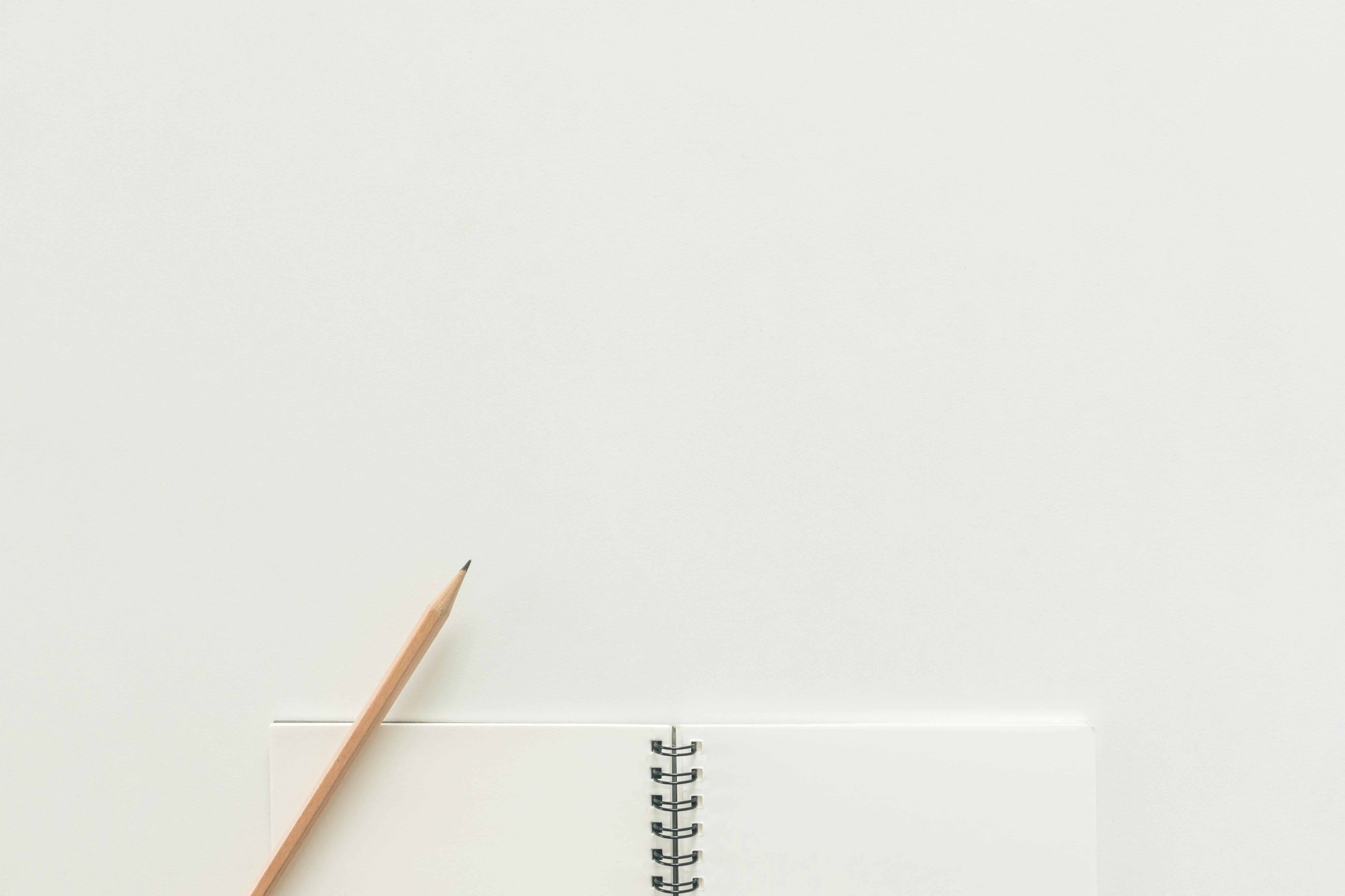 Empty sketchbook with an unmarked page and a pencil, ready for new designs or ideas.