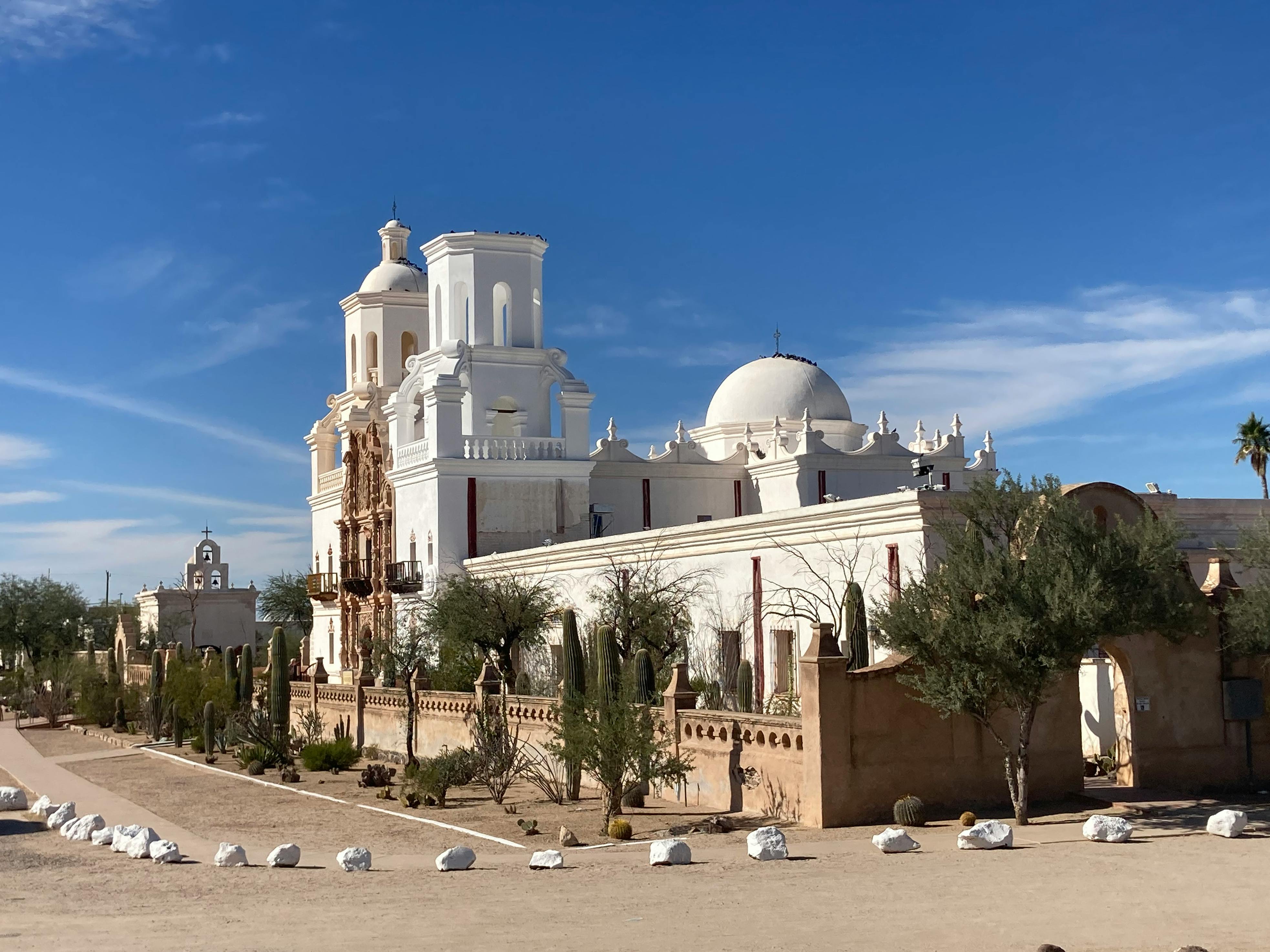 Spanish Colonial-style architecture of Mission San Xavier del Bac in Tucson, Arizona, featuring arched doorways and intricate detailing.
