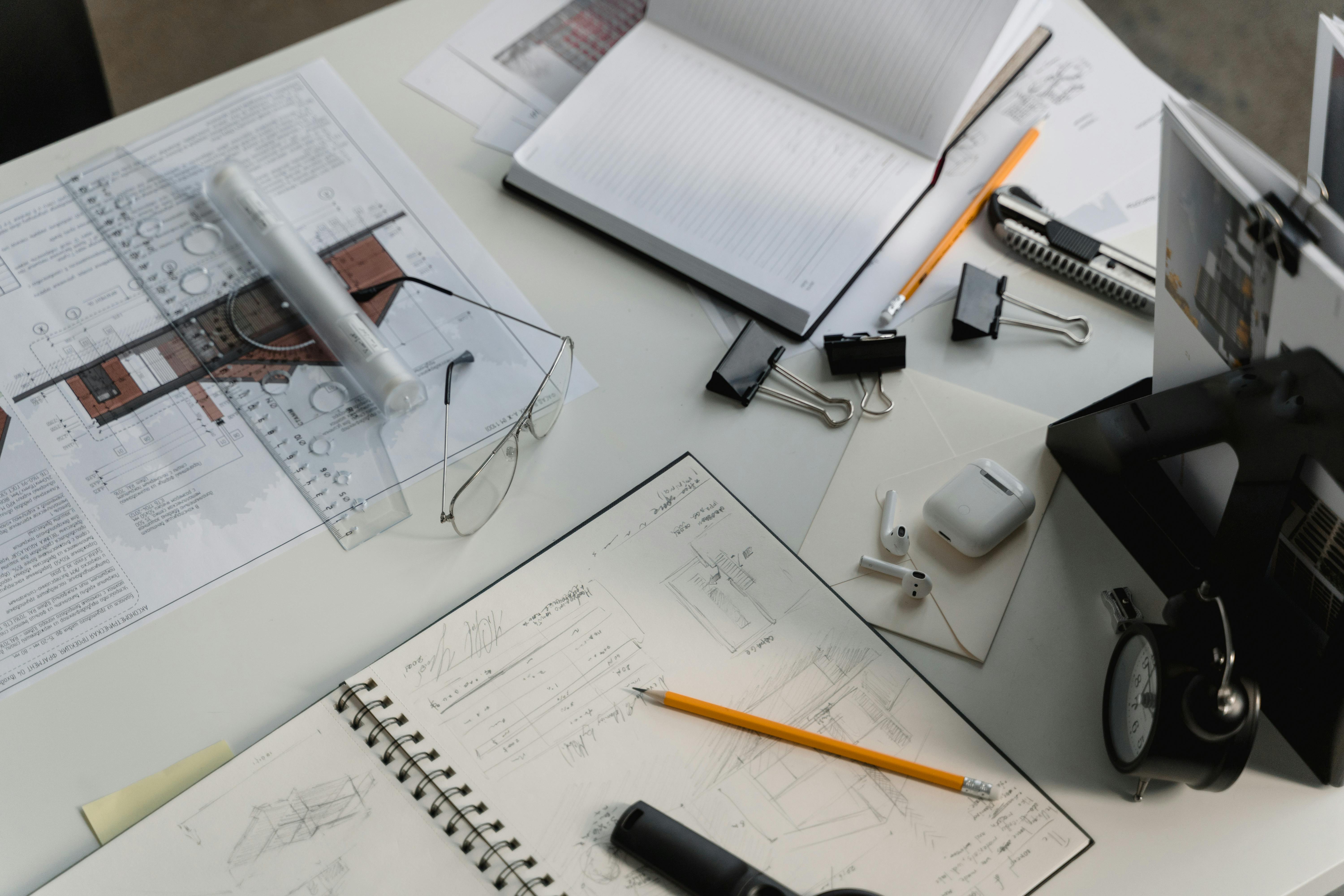 Modern architect’s office table with blueprints, laptop, and drafting tools