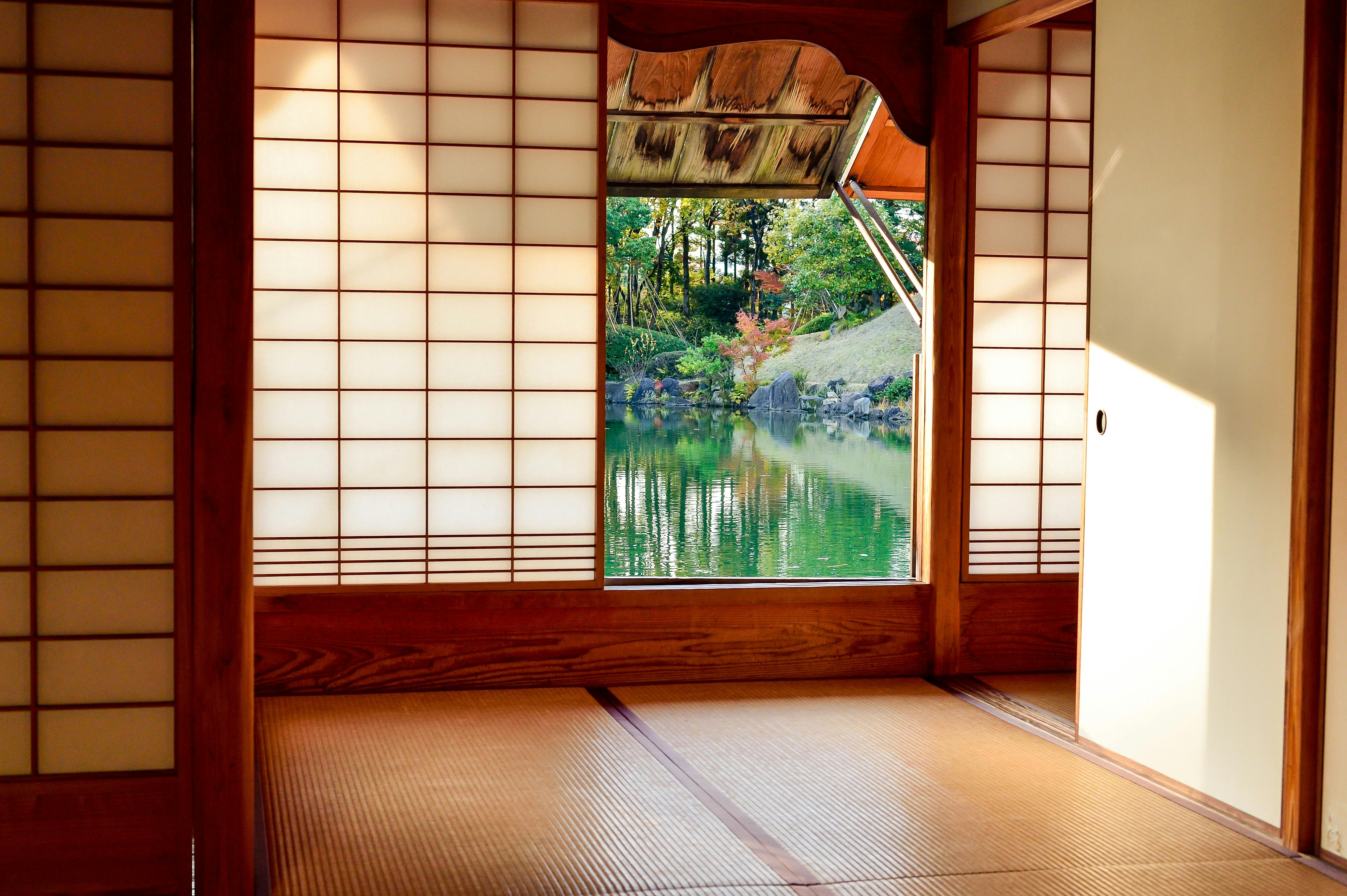 Traditional Japanese house with a brown wooden door near a body of water.