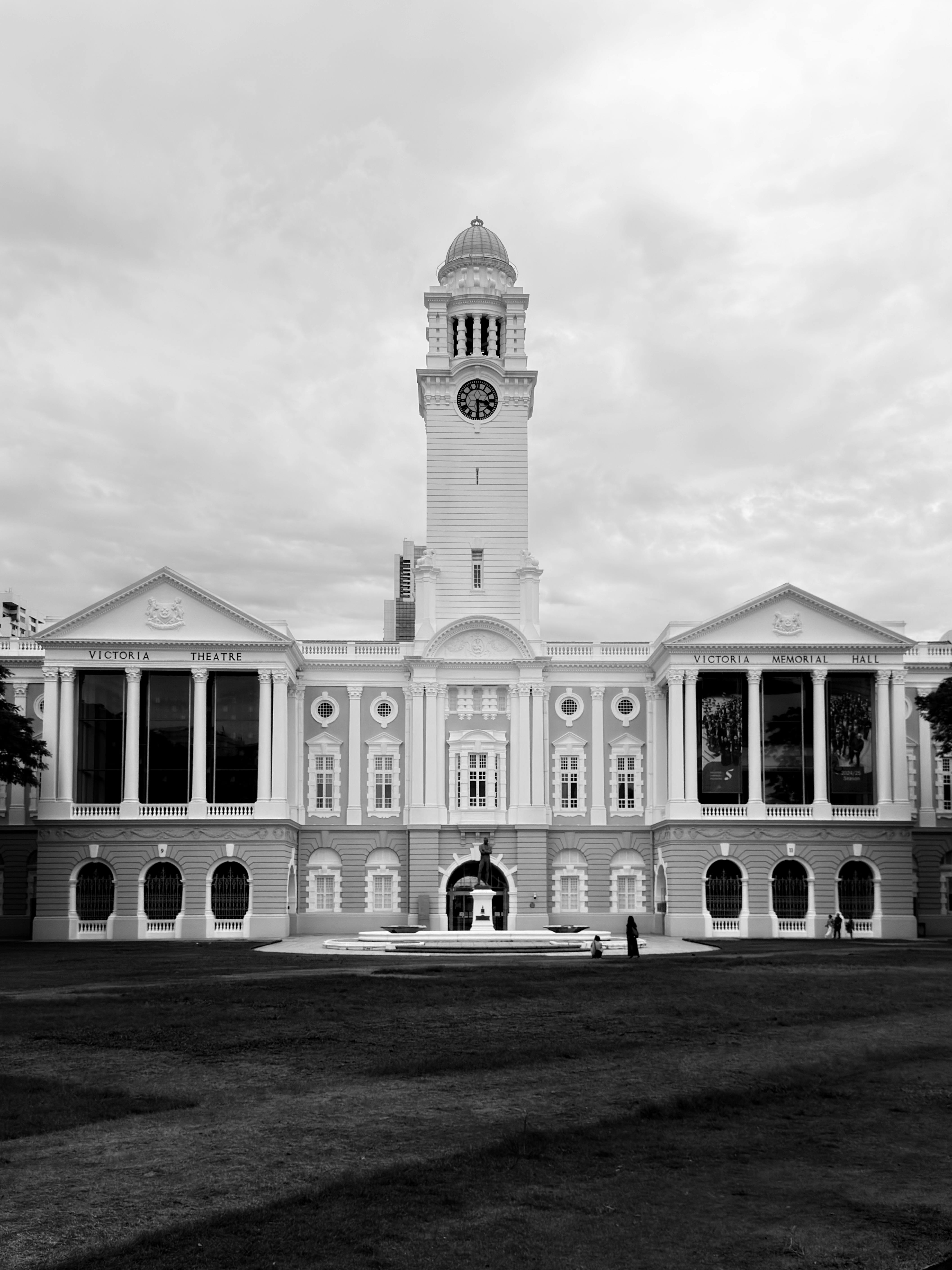 Exterior of Victoria Memorial Hall in Singapore, featuring colonial-style architecture with grand columns and classical elements in black and white.