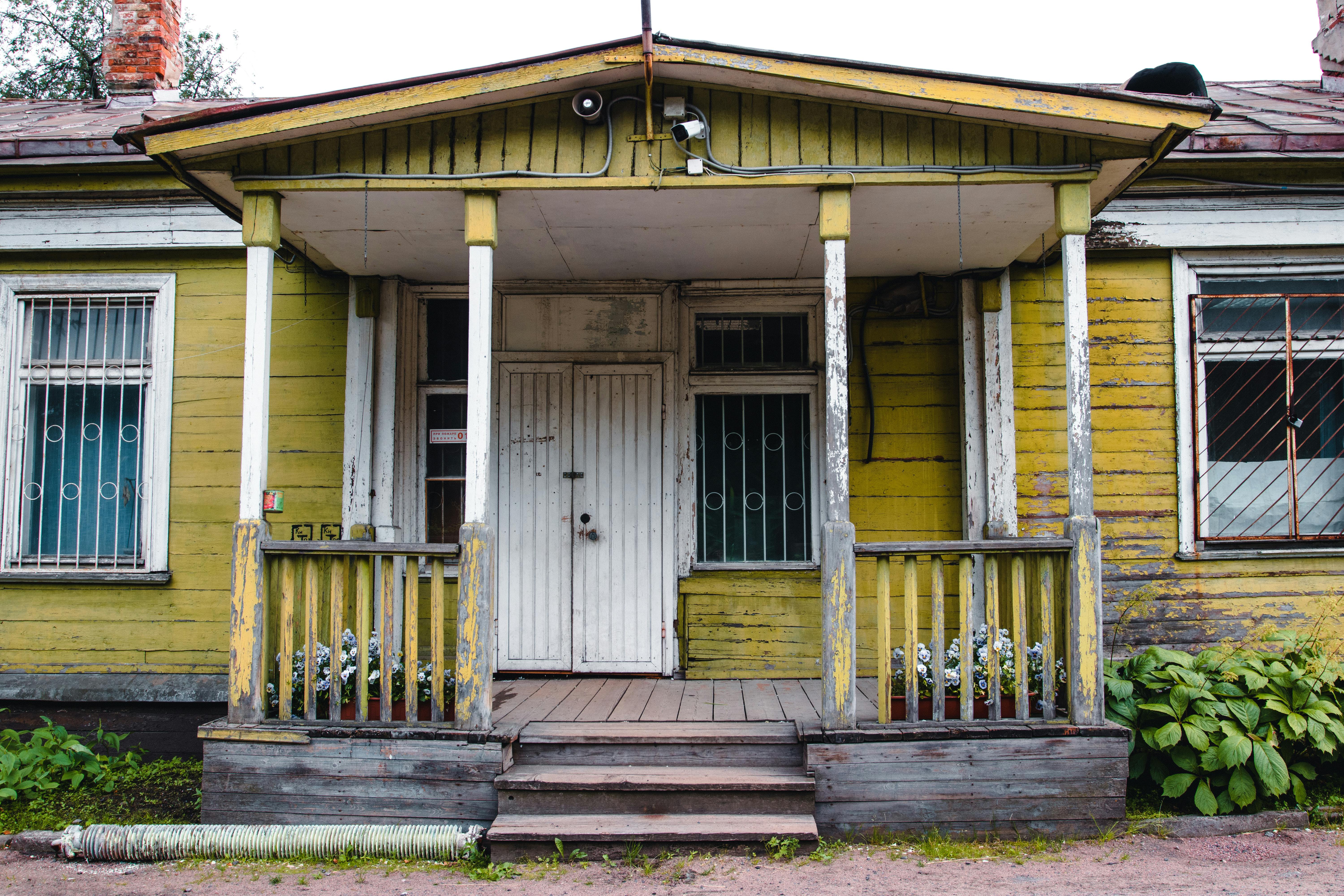 Weathered facade of a 1900s abandoned bungalow.