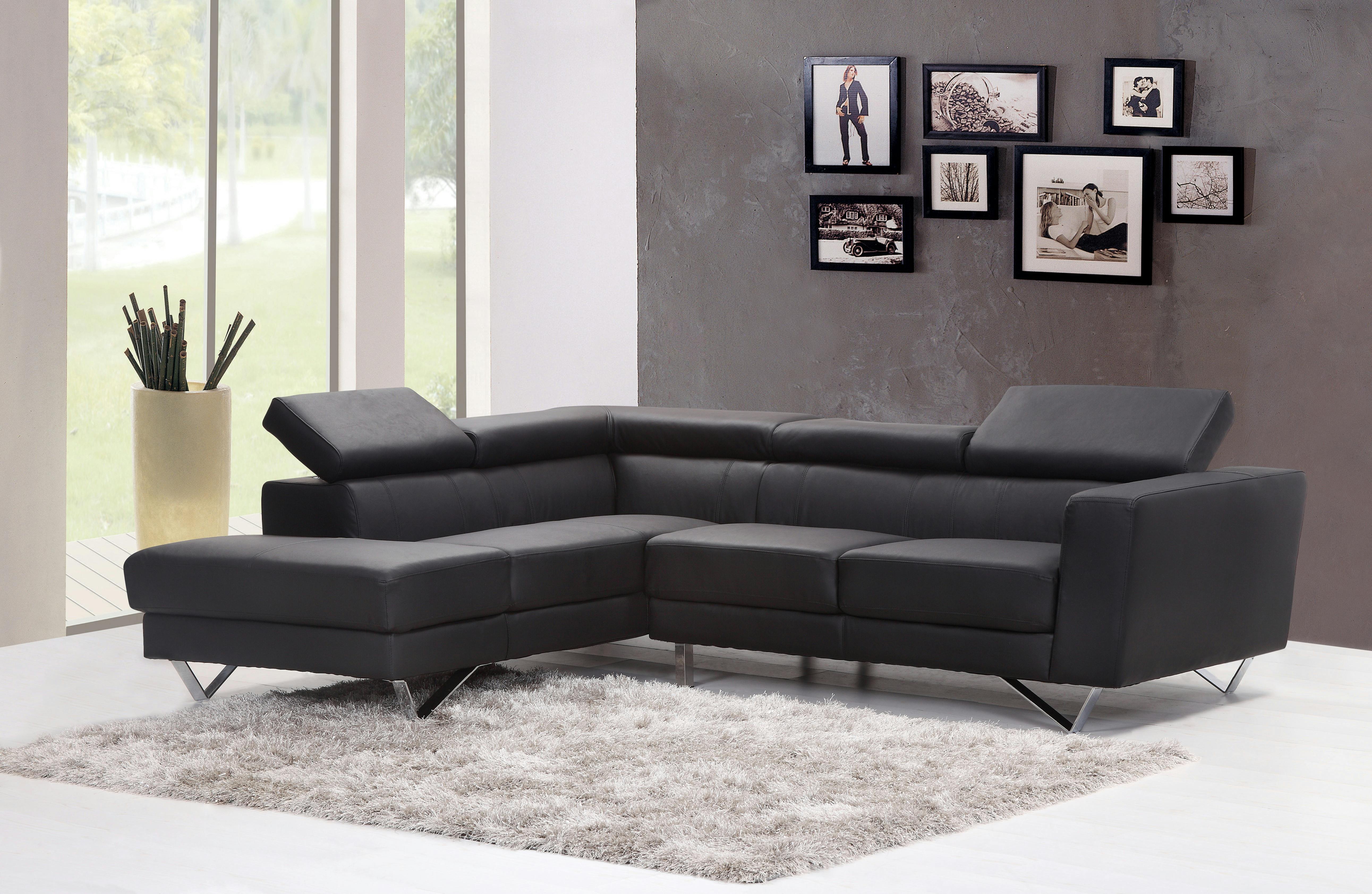 Black fabric sectional sofa by a large glass window in a modern interior setting.