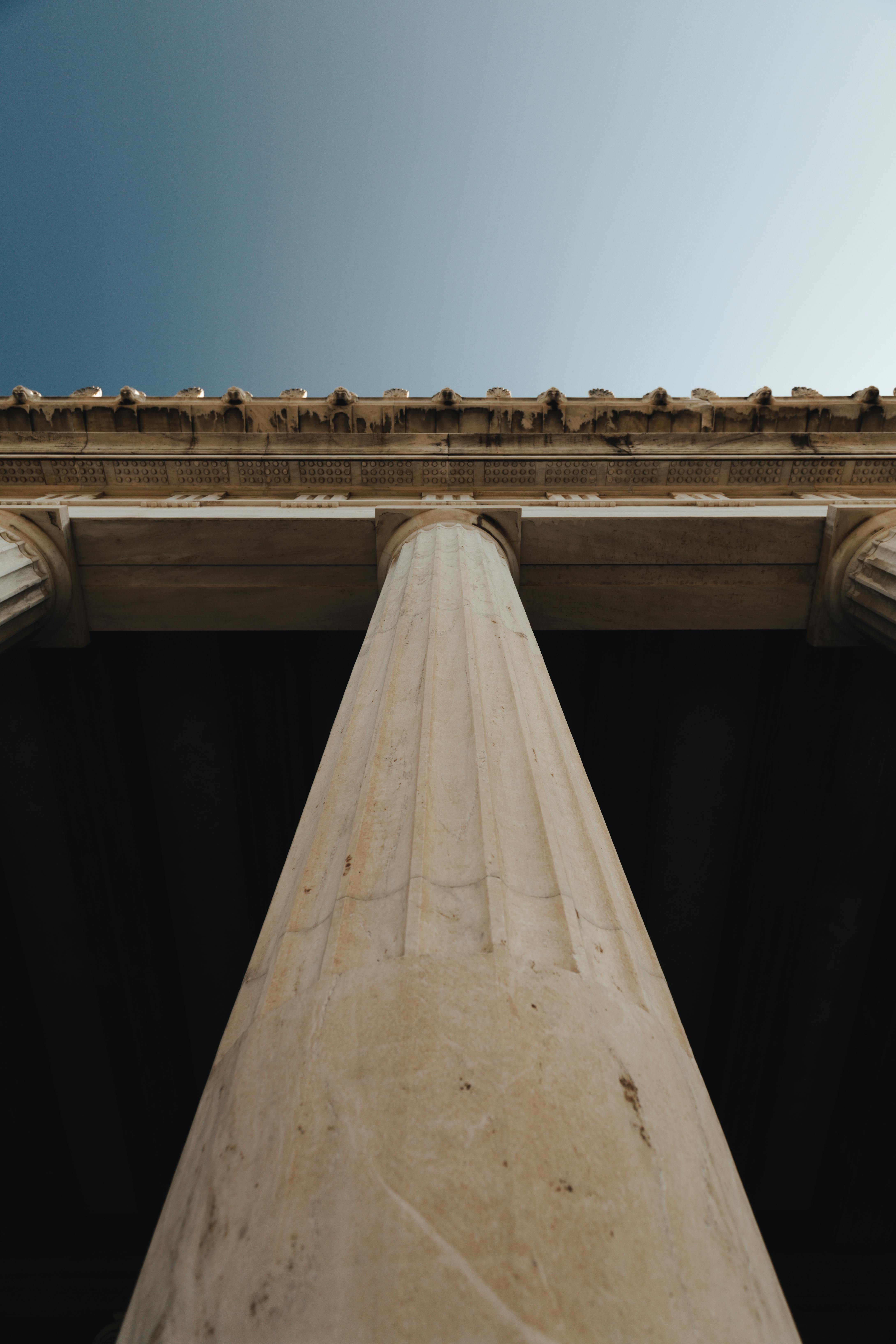 Ancient Greek Doric column with fluted shaft set against open sky.