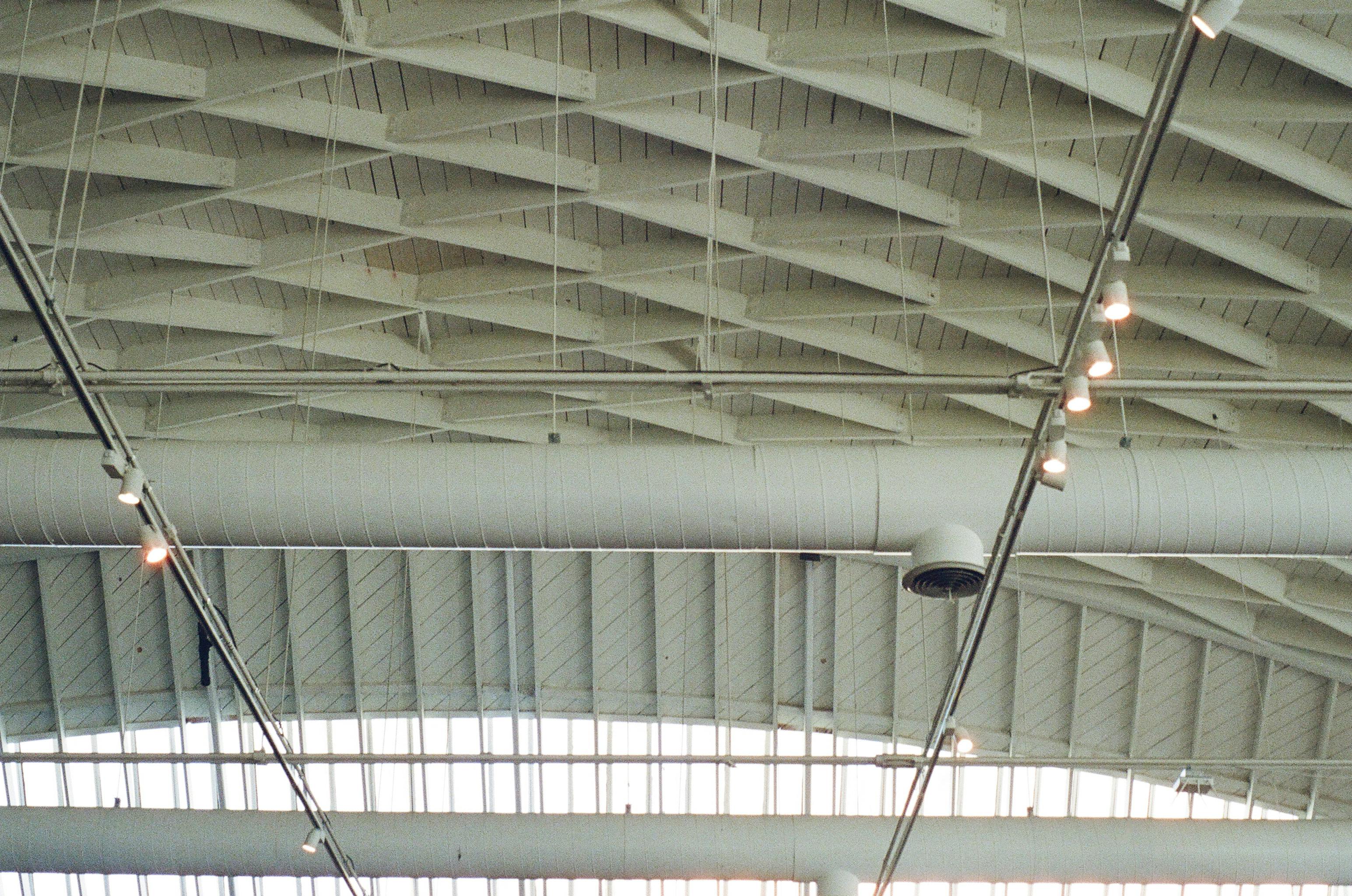 Low-angle view of a ceiling with illuminated steel trusses and modern design.
