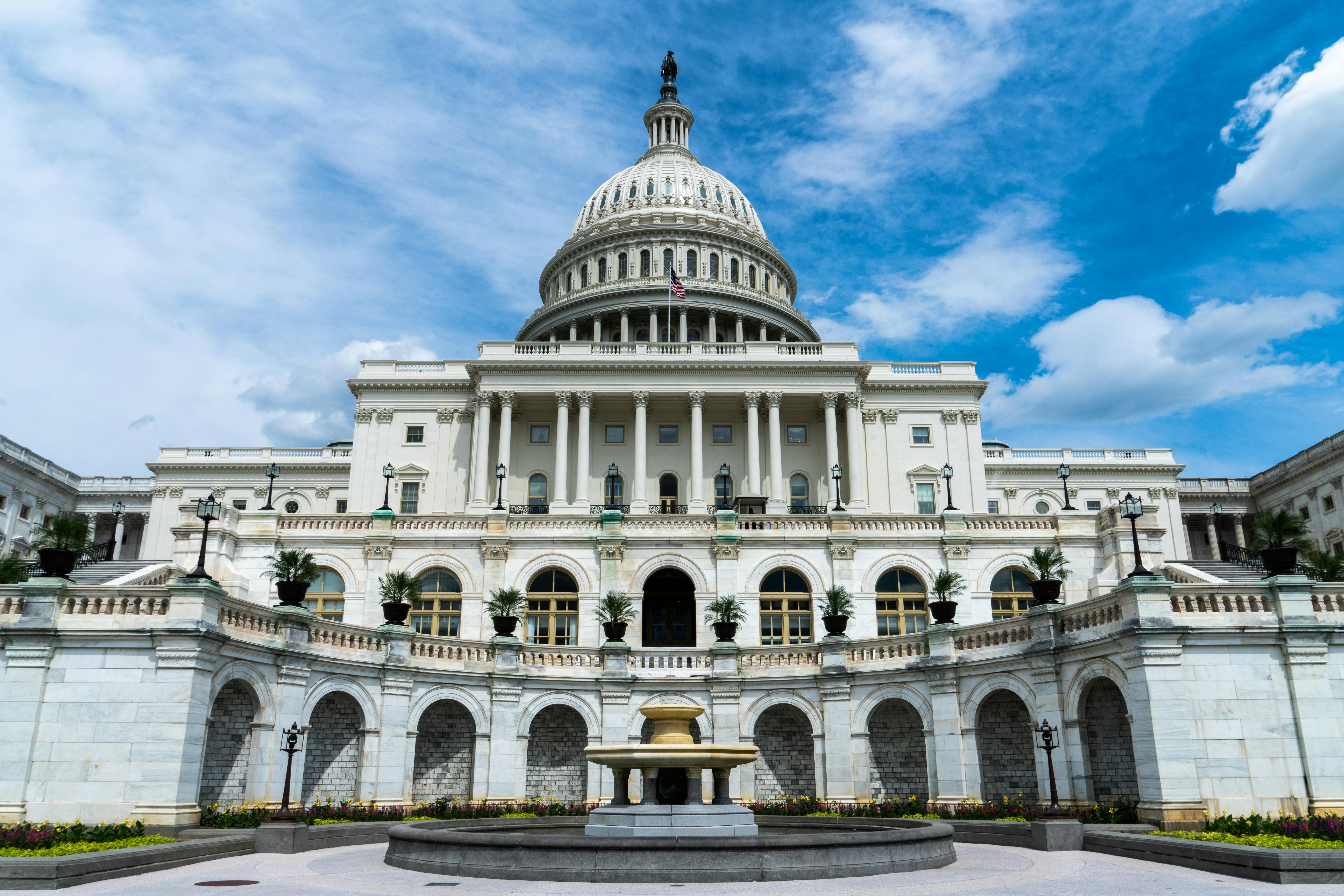 Front view of the U.S. Capitol showing symmetrical Neoclassical columns and central dome.