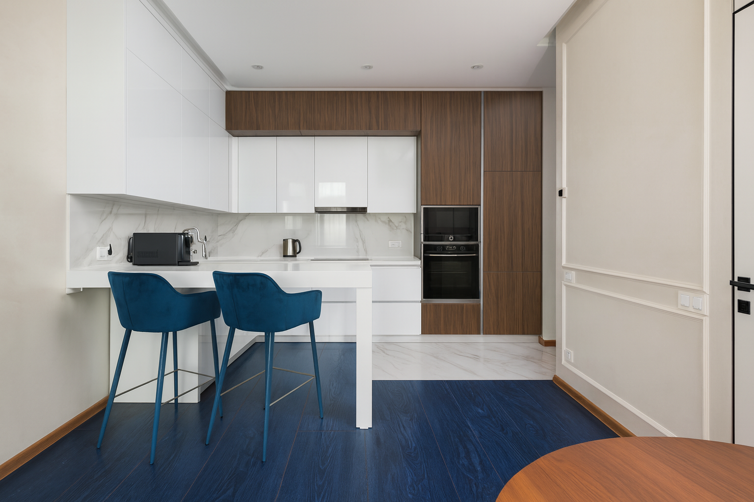 Modern kitchen with dark navy and white laminate flooring under natural light.