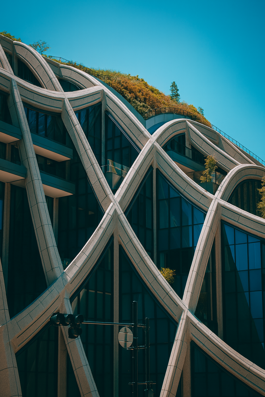 Modern building in Tokyo with unique curved lattice structure and green roof under a clear sky.