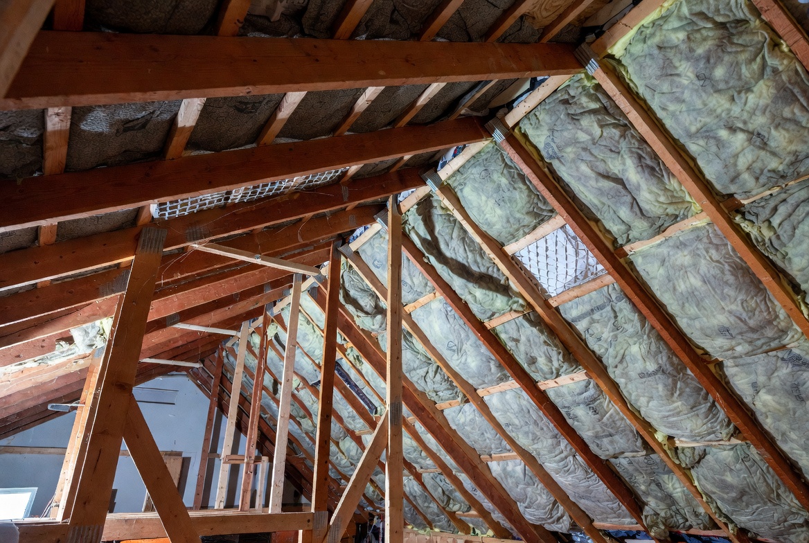 Attic retrofit with insulation installed between roof framing members during an energy-focused renovation.