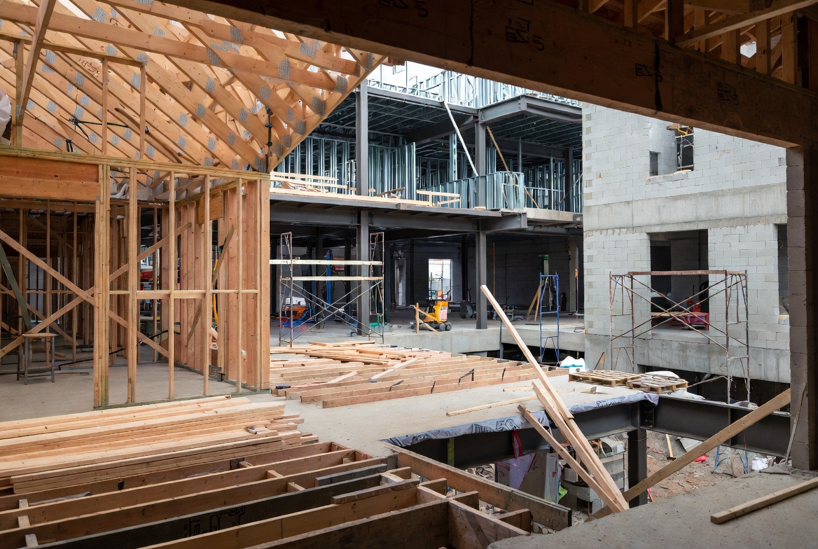 Wood, steel, and CMU building construction methods shown together on an active jobsite.