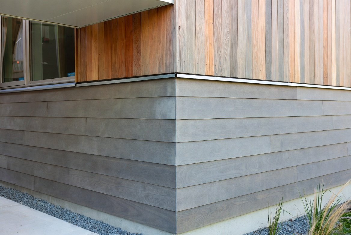 Exterior cladding corner detail with mixed horizontal wood boards and vertical wood siding.