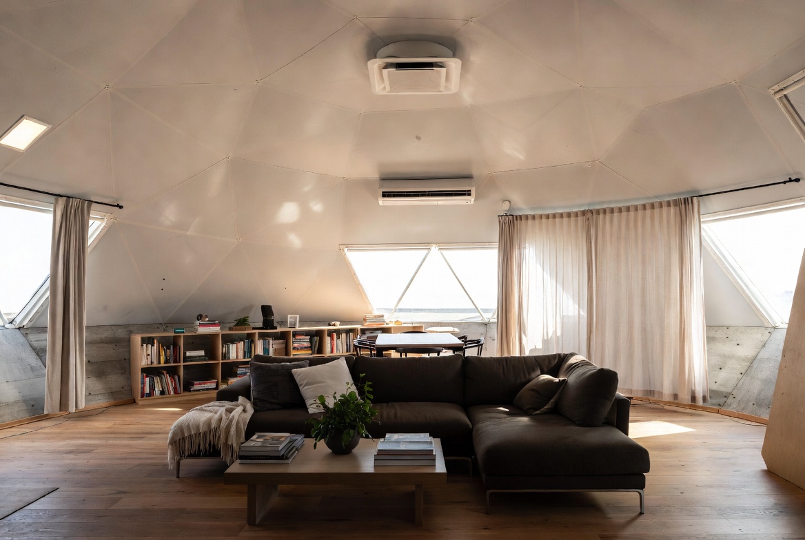Finished geodesic dome interior with seating, daylight control, and visible mini-split HVAC.