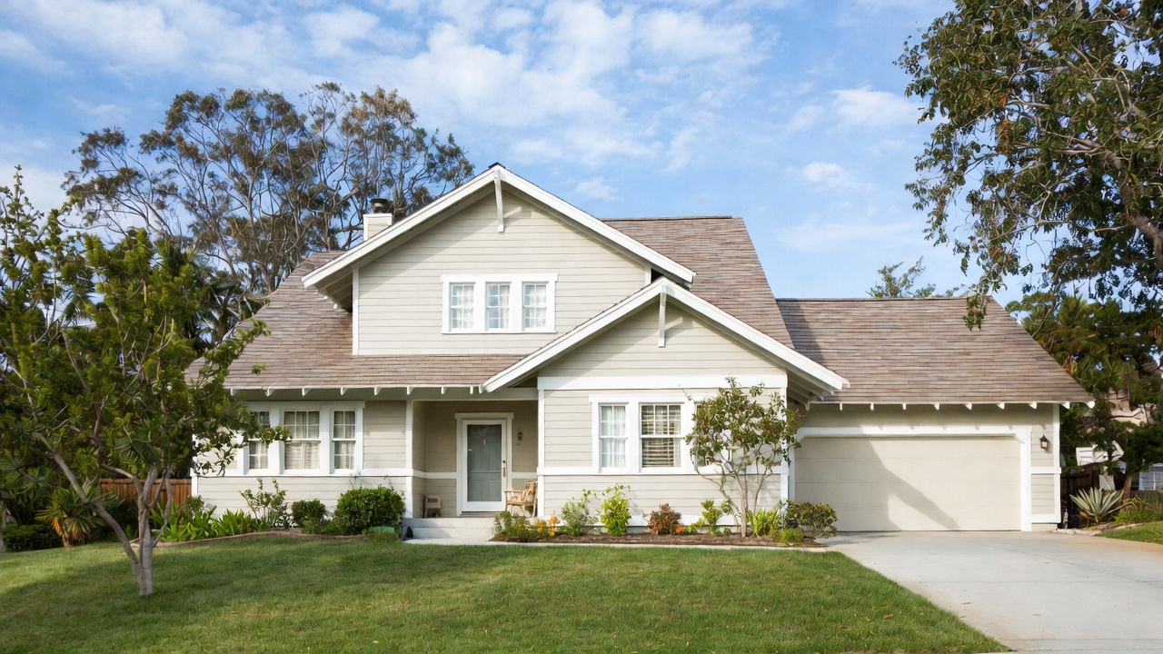 Renovated house exterior with modern cladding, upgraded windows, and a restrained two-tone envelope.
