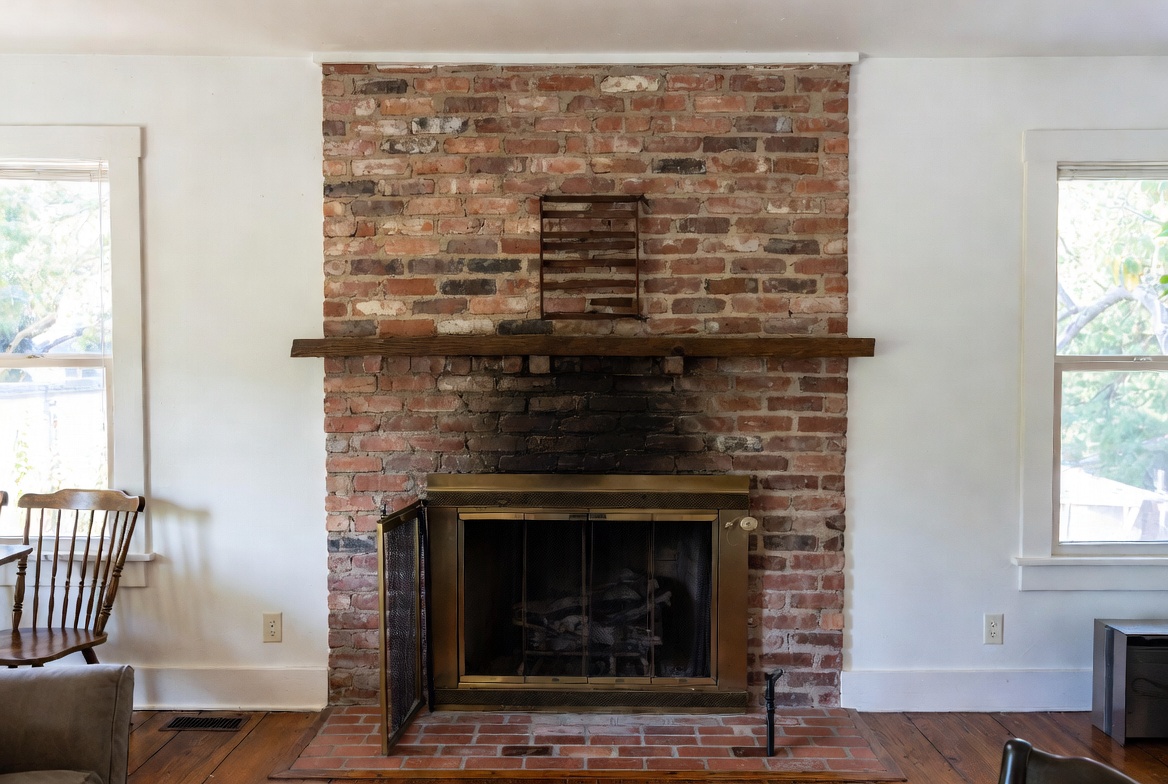 Reclaimed thin brick chimney on modest suburban house exterior.