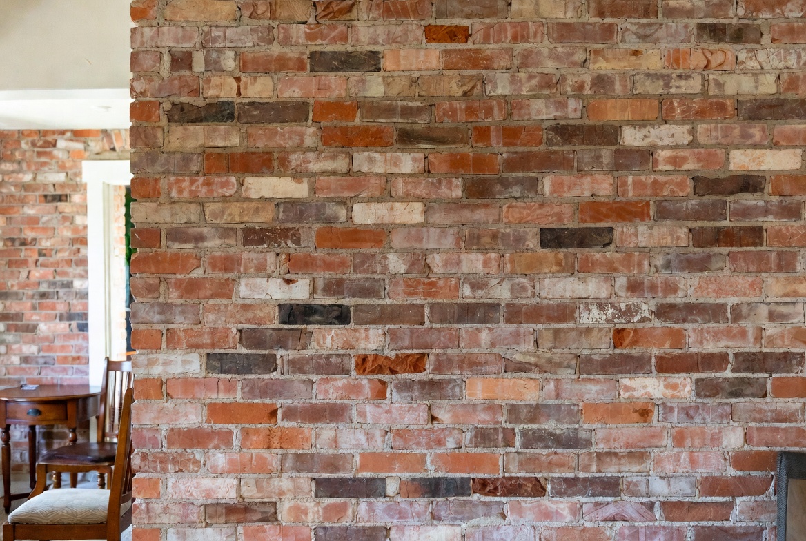 Reclaimed thin brick accent wall in a real lived-in home interior.