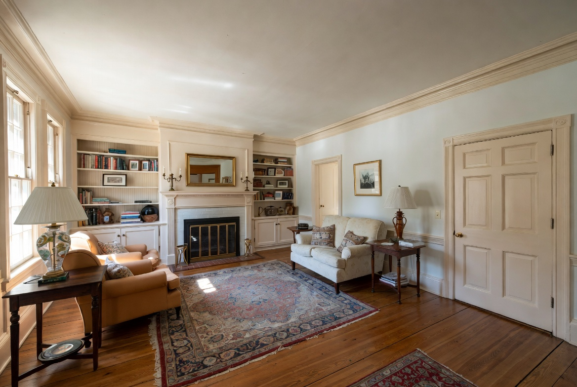 Traditional American living room with detailed trim, built-ins, fireplace, and classic furniture.