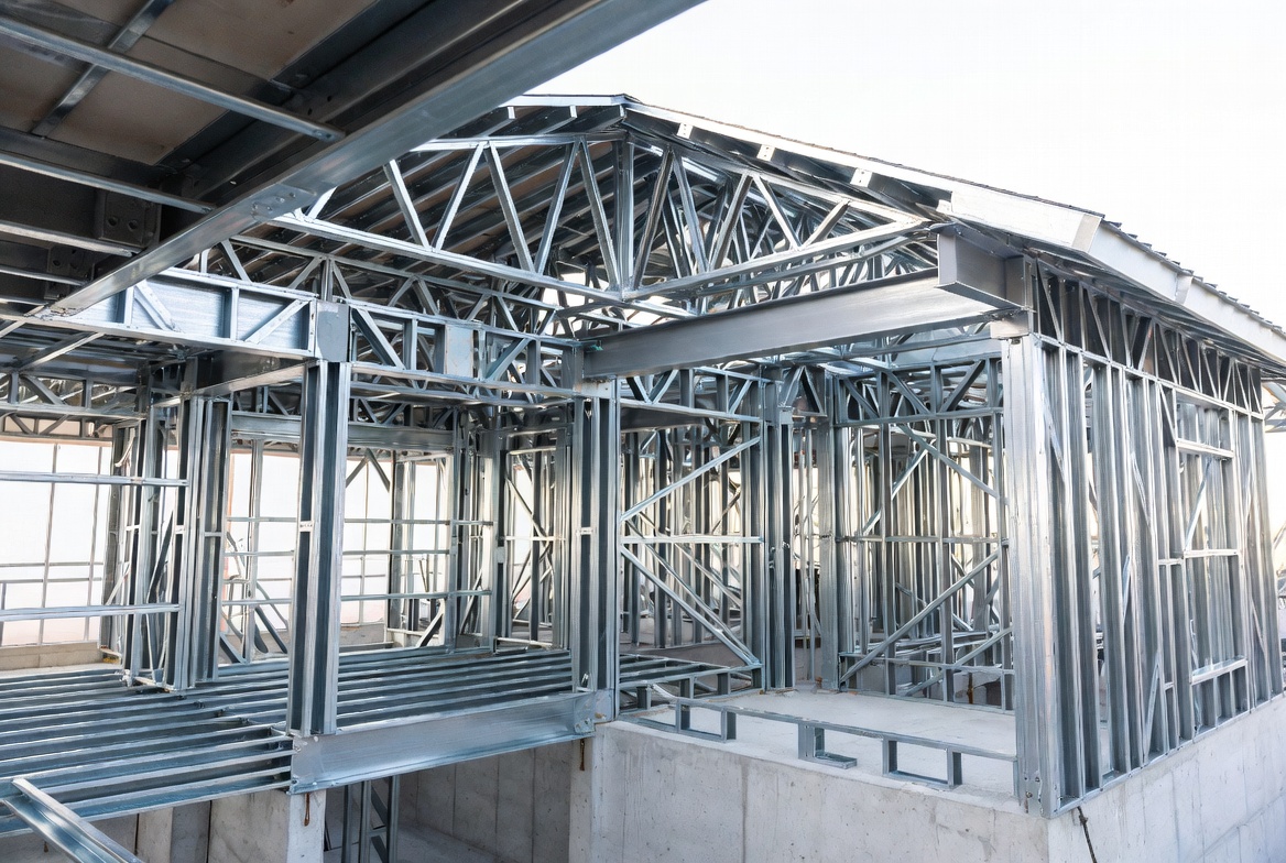 Cold-formed steel house frame with steel roof trusses over the main volume.