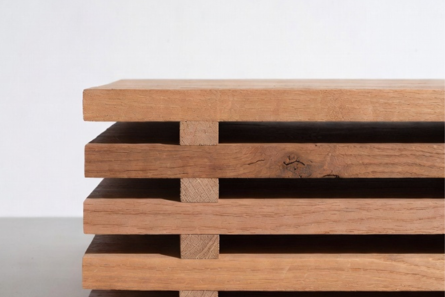 Wood boards stacked with spacer sticks to acclimate indoors.