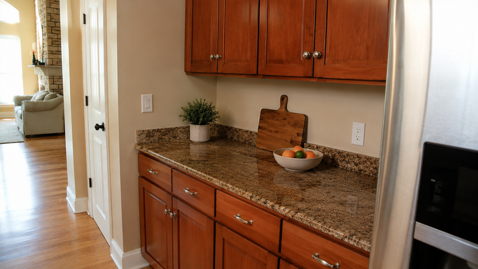 Converted 2000s kitchen desk with cherry cabinets, granite counter, drawers, and clean storage.