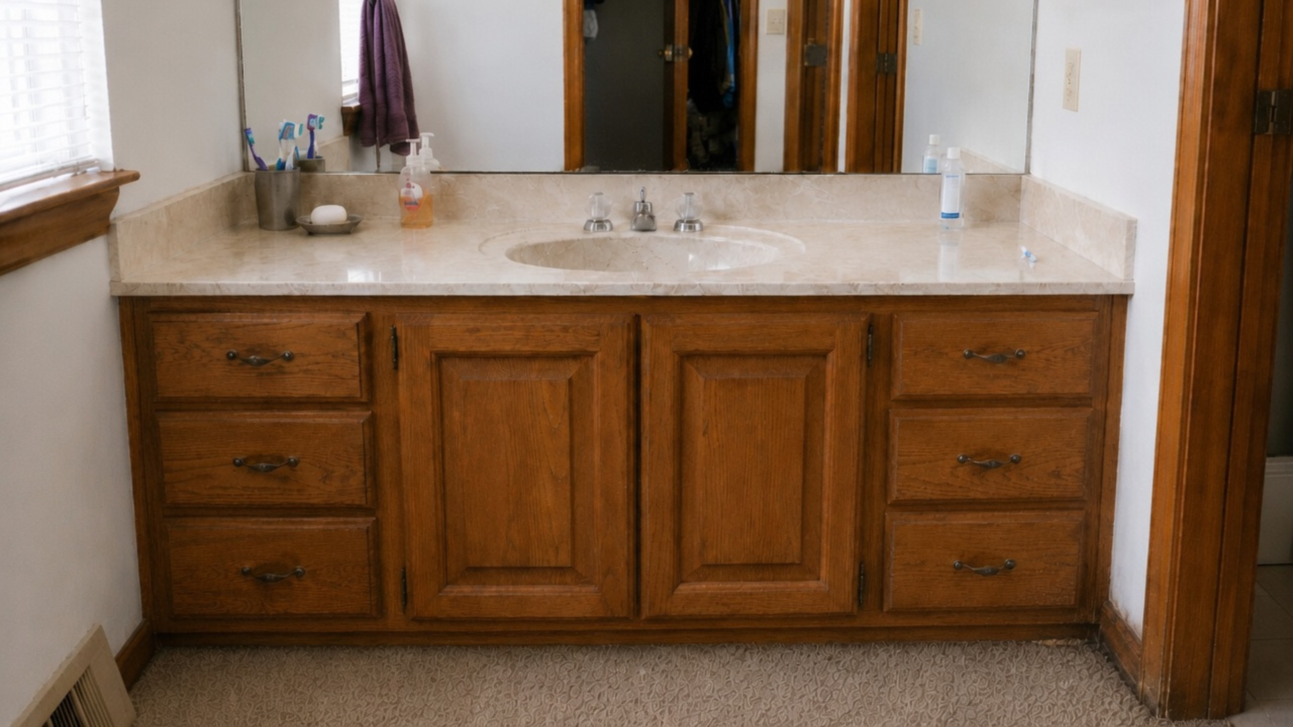 Water damage at the base of a 1980s bathroom vanity cabinet.