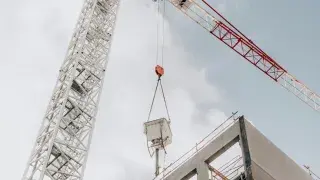 A towering crane at a modern construction site, lifting materials for high-rise development.