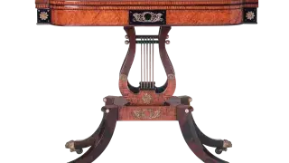 An ornate card table made from mahogany wood, featuring intricate details and a classic design.