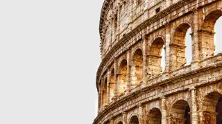 The Colosseum in Rome under clear skies.