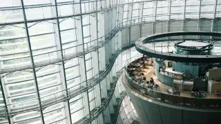 Contemporary human-centered architecture in Tokyo featuring a glass façade that brings in natural light and rounded interior spaces designed to encourage easier interaction among workers.