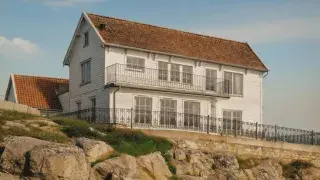A restored 1910s white Scandinavian timber house with original architectural details.