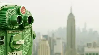 Green binocular viewer with Empire State in background.