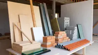 Assorted construction materials displayed on a jobsite table inside a partially built structure.