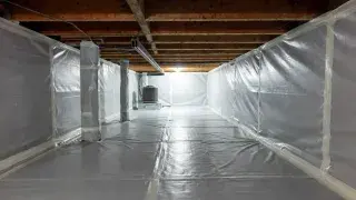 Encapsulated crawl space with sealed floor liner, wall liner, wrapped piers, and visible floor framing above.