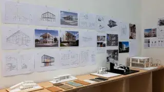 Architecture studio wall with sustainable design course boards, models, and material samples.