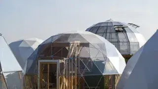 Cluster of geodesic dome structures with visible faceted framing and translucent exterior panels.
