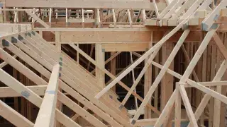 Diagonal roof bracing installed across wood framing during house construction.