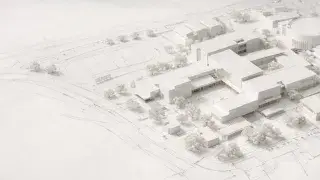 School campus architectural site model arranged over plan drawings.